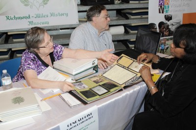 A genealogist provides free consultations at a community history event hosted by History United and regional libraries.